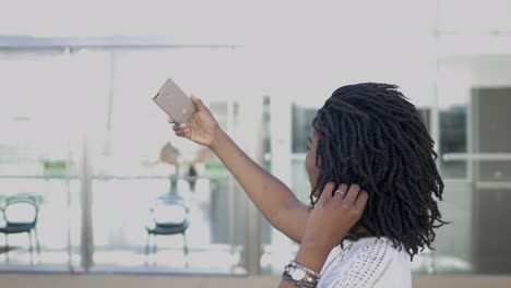 Smiling-African-American-girl-taking-selfie-with-smartphone.